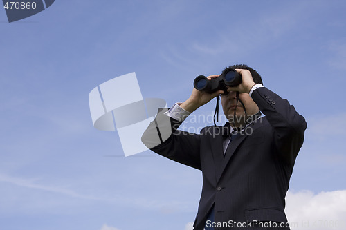 Image of Businessman looking through binoculars