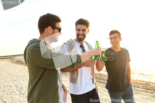 Image of young men toasting non alcoholic beer on beach