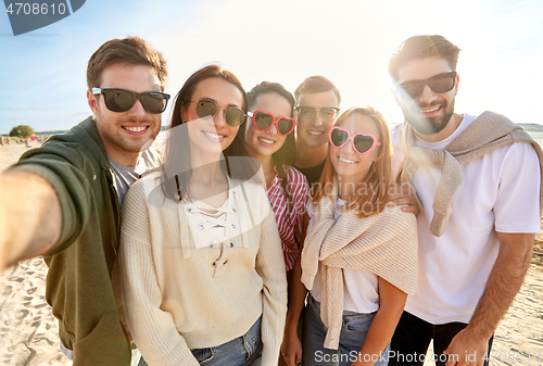 Image of happy friends taking selfie on summer beach