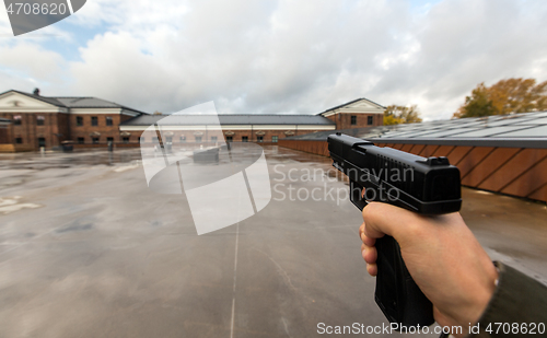 Image of POV of male hands shooting with semi-automatic gun