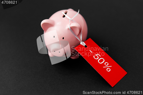 Image of piggy bank with red sale tag on black