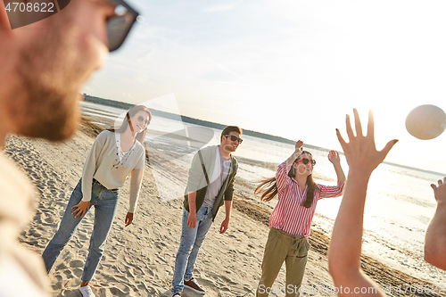 Image of friends playing volleyball on beach in summer