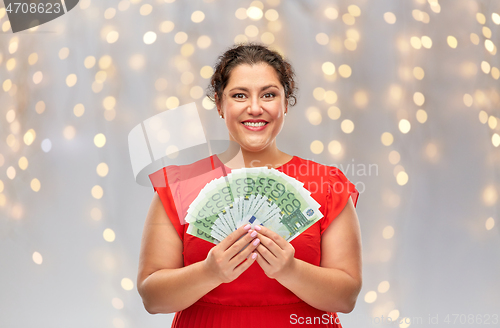 Image of happy woman holding hundreds of money banknotes