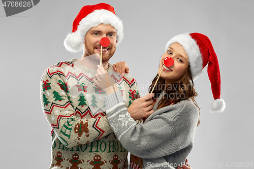 Image of couple with christmas party props in ugly sweaters