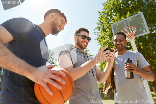 Image of men with smartphone on basketball playground