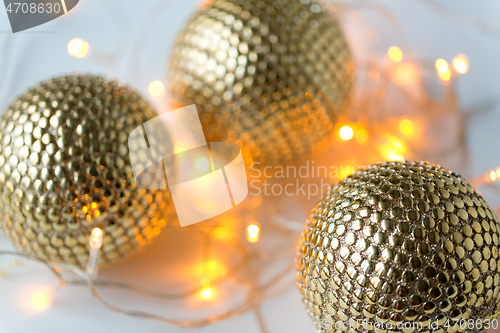 Image of golden christmas balls and garland lights