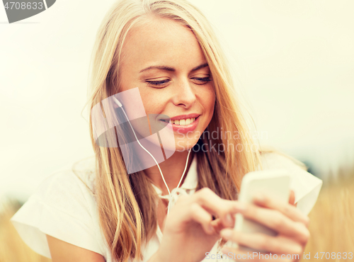 Image of happy woman with smartphone and earphones