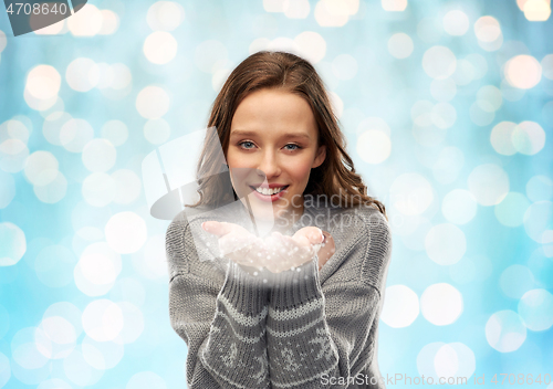 Image of young woman in christmas sweater with fairy dust