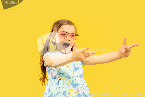 Image of Beautiful emotional little girl isolated on yellow background