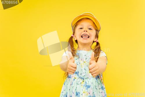 Image of Beautiful emotional little girl isolated on yellow background