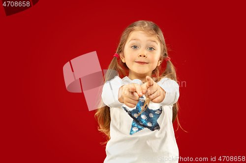 Image of Beautiful emotional little girl isolated on red background