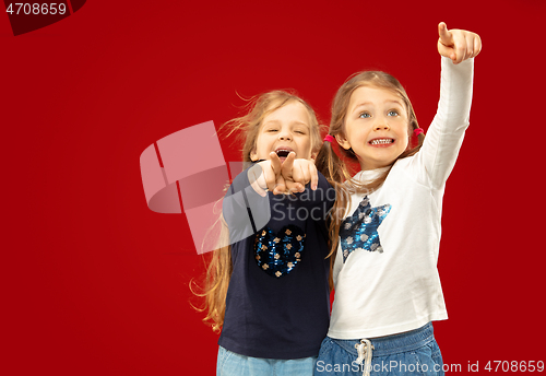 Image of Beautiful emotional little girls isolated on red background