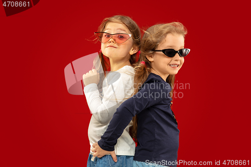 Image of Beautiful emotional little girls isolated on red background