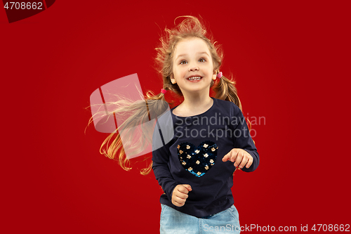 Image of Beautiful emotional little girl isolated on red background