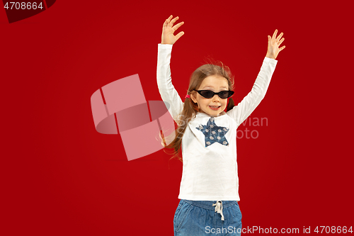 Image of Beautiful emotional little girl isolated on red background