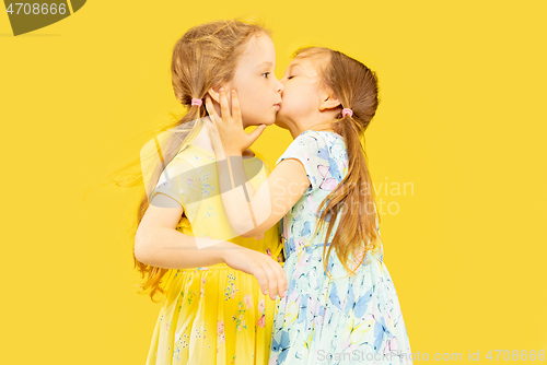 Image of Beautiful emotional little girls isolated on yellow background