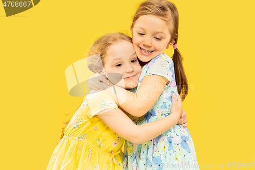 Image of Beautiful emotional little girls isolated on yellow background