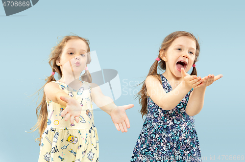 Image of Beautiful emotional little girls isolated on blue background