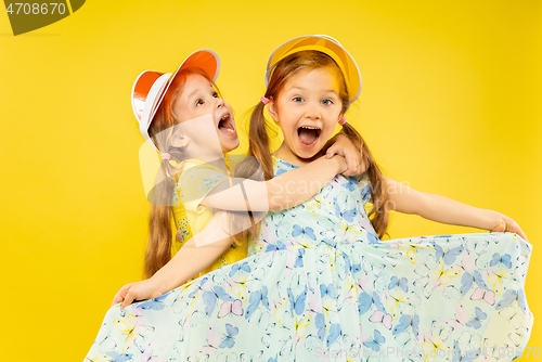 Image of Beautiful emotional little girls isolated on yellow background
