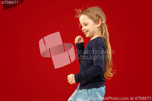 Image of Beautiful emotional little girl isolated on red background