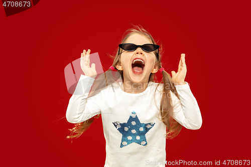 Image of Beautiful emotional little girl isolated on red background