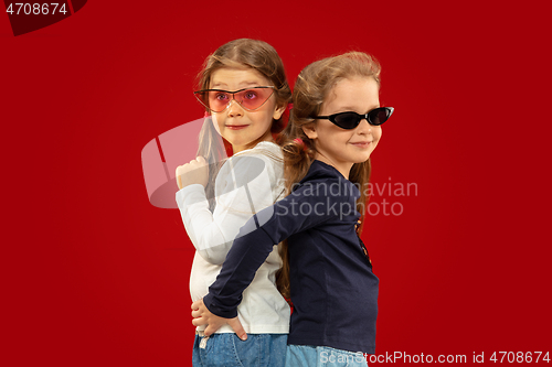 Image of Beautiful emotional little girls isolated on red background