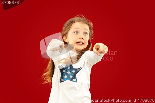 Image of Beautiful emotional little girl isolated on red background