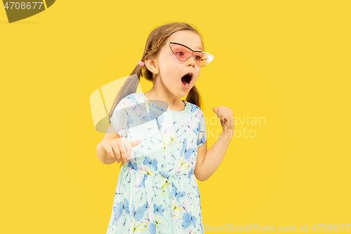 Image of Beautiful emotional little girl isolated on yellow background