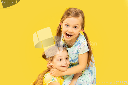Image of Beautiful emotional little girls isolated on yellow background