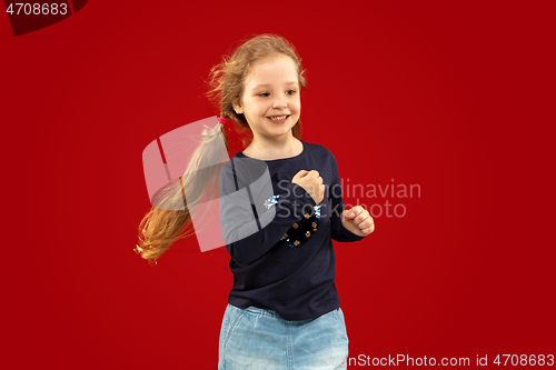 Image of Beautiful emotional little girl isolated on red background