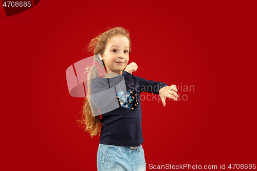 Image of Beautiful emotional little girl isolated on red background