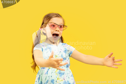 Image of Beautiful emotional little girl isolated on yellow background