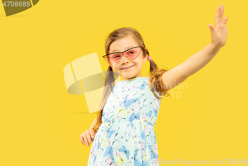 Image of Beautiful emotional little girl isolated on yellow background