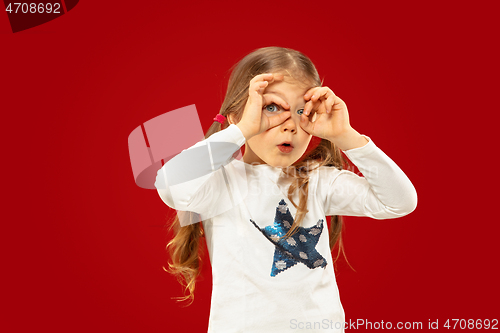 Image of Beautiful emotional little girl isolated on red background