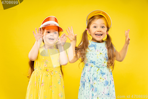 Image of Beautiful emotional little girls isolated on yellow background