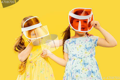 Image of Beautiful emotional little girls isolated on yellow background