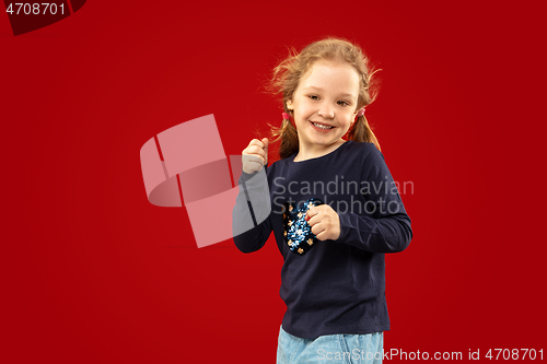 Image of Beautiful emotional little girl isolated on red background