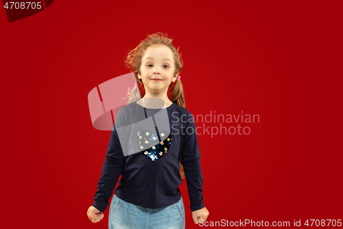 Image of Beautiful emotional little girl isolated on red background