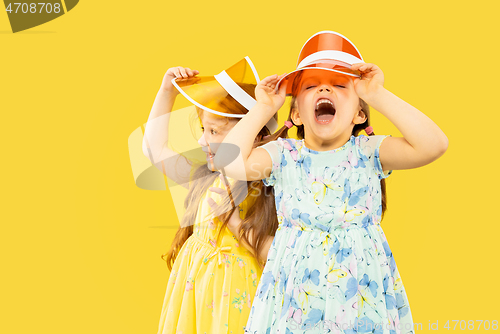 Image of Beautiful emotional little girls isolated on yellow background