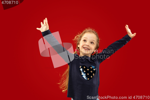 Image of Beautiful emotional little girl isolated on red background