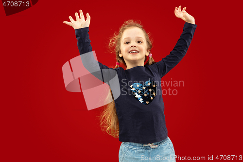 Image of Beautiful emotional little girl isolated on red background