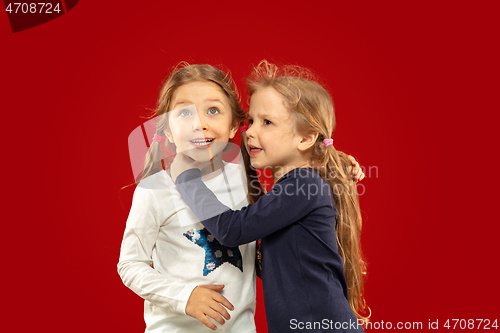 Image of Beautiful emotional little girls isolated on red background