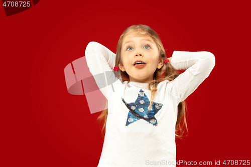 Image of Beautiful emotional little girl isolated on red background