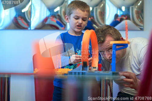 Image of Father and children playing car toy game