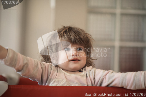 Image of little baby girl with strange hairstyle and curlers