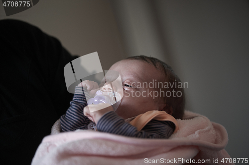 Image of grandmother holding newborn baby at home