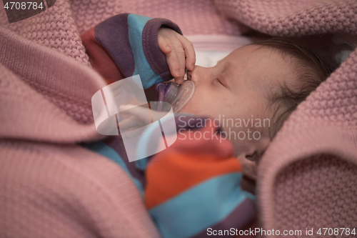 Image of One month newborn baby sleeping in bed