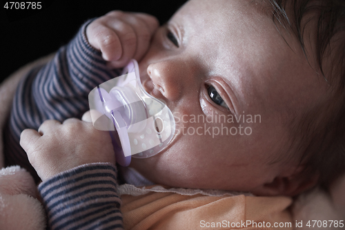 Image of One month newborn baby sleeping in bed