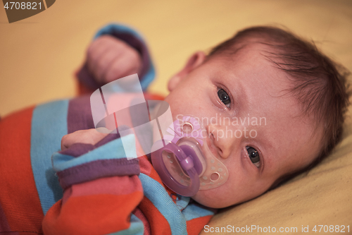 Image of One month newborn baby sleeping in bed