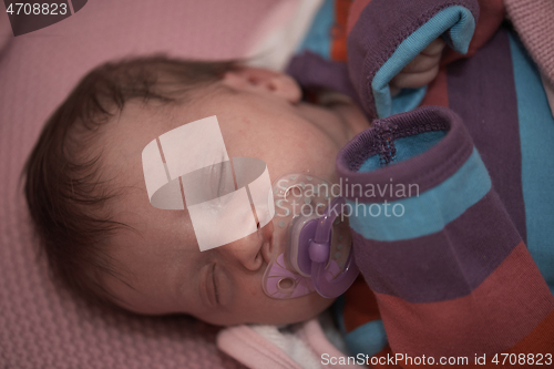 Image of One month newborn baby sleeping in bed